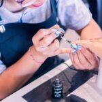 Nail artist meticulously applying nail polish in a beauty salon environment.
