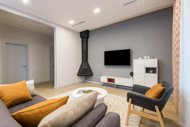 Photo of a modern simple living room with sofa, chair, entertainment center, and floating black fireplace
